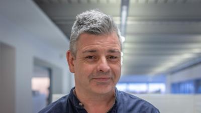 Headshot of Gavin Sorby. A man smiling, wearing a navy blue shirt.