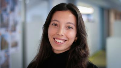 Headshot of Jessica Miles. A smiling woman with long brown hair, wearing a black jumper.
