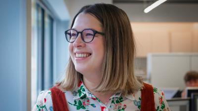 Headshot of Kimberley Corrall. A smiling woman wearing glasses and a floral shirt.