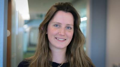 Headshot of Libby Butterworth. A woman smiling, wearing a navy jumper.