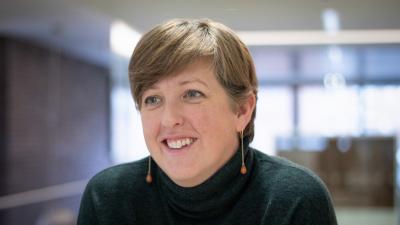 Headshot of Liz Jackson. A woman smiling, wearing a black jumper.