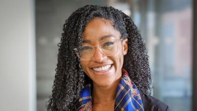 Headshot of Samantha Knights. A woman smiling, wearing a blue scarf.