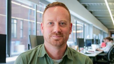 Headshot of Paul Hobson. A man smiling, wearing a green shirt.