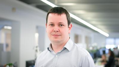 Headshot of Andy Balmer. A man smiling at the camera wearing a white shirt.