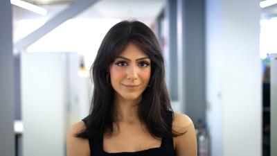 Headshot of Shaadi Karimi. A woman wearing a black top smiling at the camera.