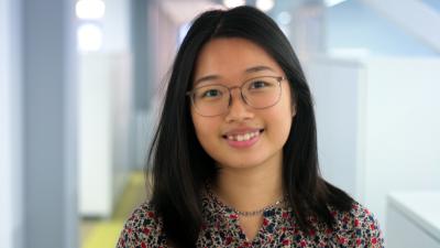 Headshot of Hannah Chin. Woman smiling at the camera, wearing a patterned shirt.