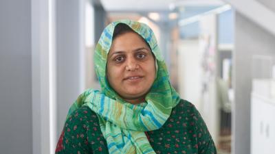 Headshot of Saima Shakoor, a woman wearing a green headscarf looking at the camera.