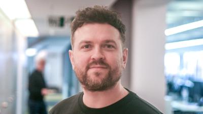 Headshot of Paul Wright. A man wearing a black t-shirt.