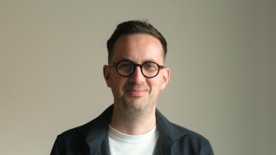 Headshot of Edward Kepczyk. A smiling man wearing a dark blue shirt and white t-shirt underneath.