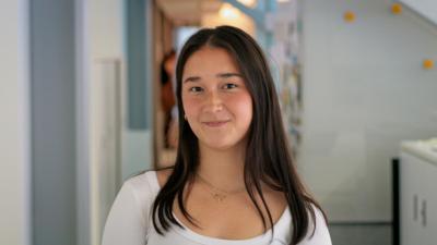 A headshot of a girl with long dark hair wearing a white t-shirt
