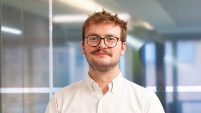 Man wearing a white shirt looking into the camera