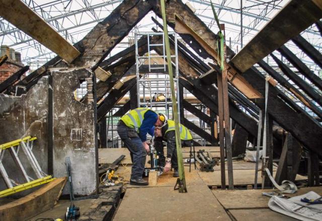 workers in hi-vis working on scaffolded wythenshawe hall roof