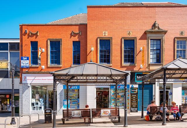 A red brick building in Morley with benches in front of it