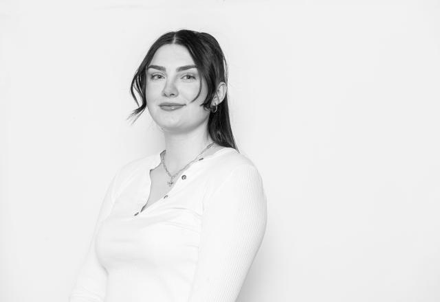 Headshot of Rebecca Jackson, a black and white photo of a girl wearing a white t-shirt