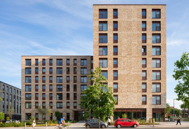 an apartment building in buff brick on a sunny day