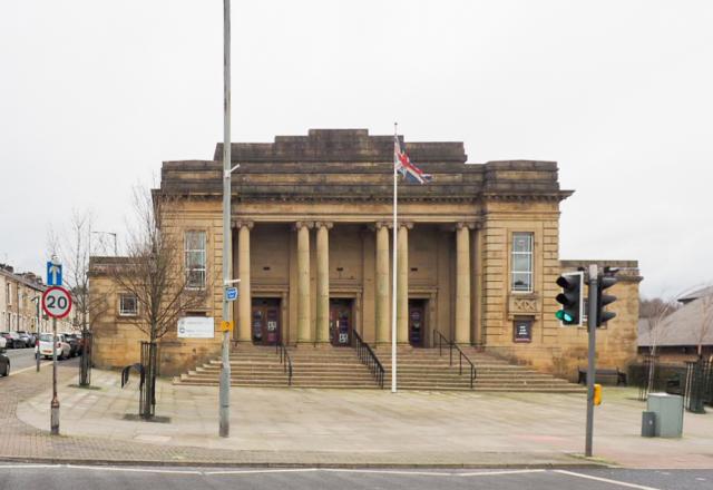 Mercer Hall, a brown stone building with columns on a street