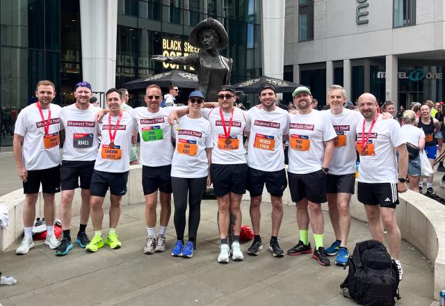 Group of Buttress employees, standing side by side wearing marathon medals