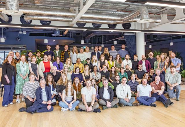 Group photo of 80 people sitting or standing and looking into the camera