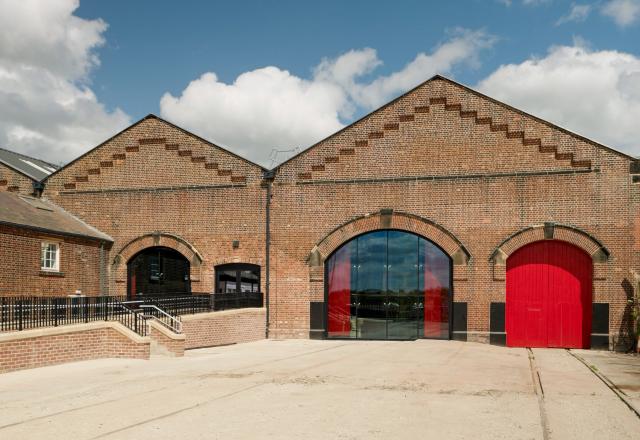 Exterior of Station Hall - a red brick building with a red door and a glazed windw