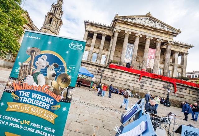 Exterior photo of the Harris Museum Preston with people gathered outside and a banner.