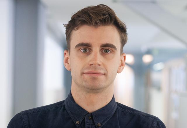 A young man wearing a dark shirt, with brown hair.