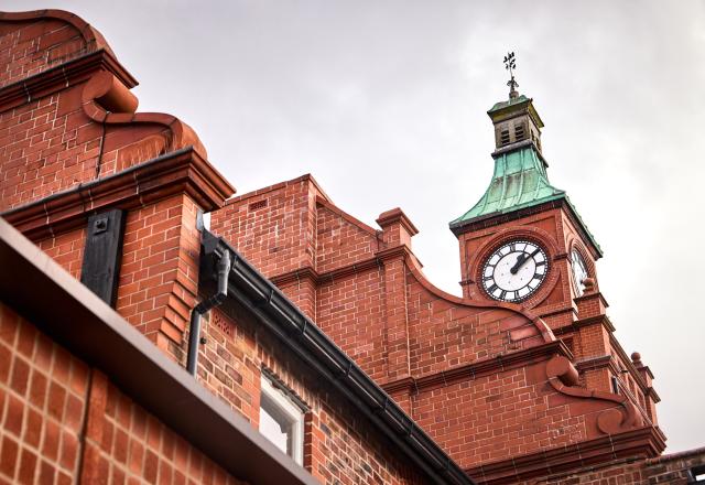 A clock tower on a red brick heritage building