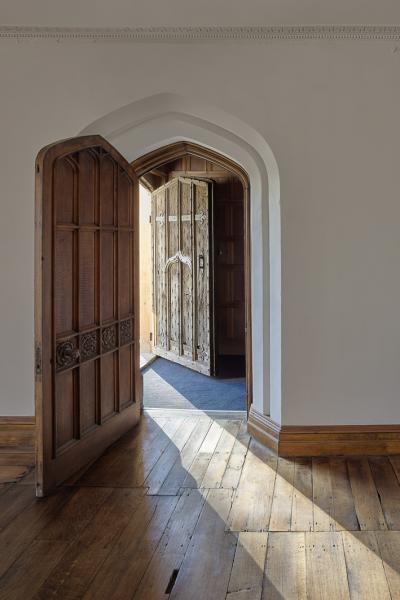 An old door opens with sun streaming through