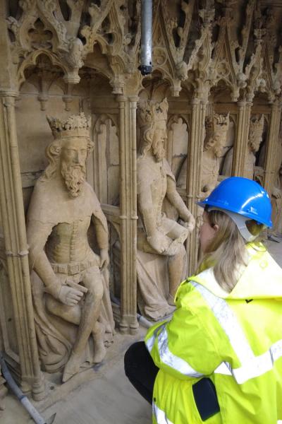 a lady look at some stone statues closely