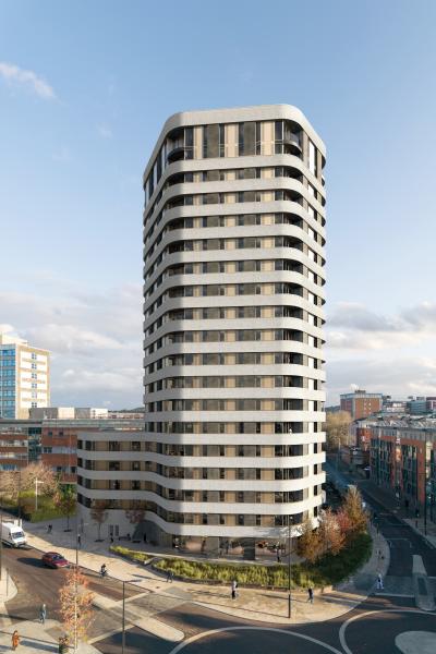 Tall tower from afar - horizontal bands of grey and windows. Landscaped street at the bottom of the tower with trees.