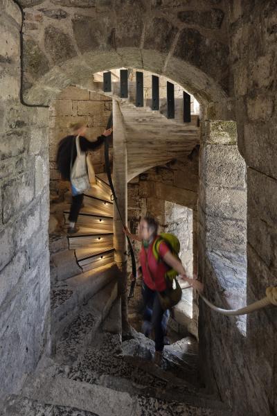two ladies walk up the spiral stair at caernarfon castle
