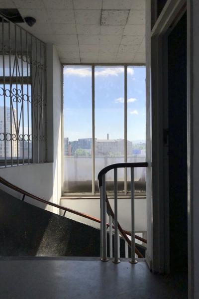 the top of a spiral staircase with a large window looking over manchester's skyline