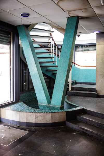 a turquoise tiled structural column in front of the stairs in hilton house before redevelopment