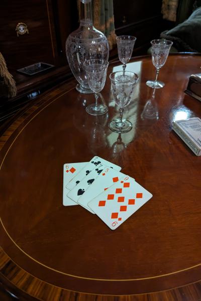 Polished table with playing cards and crystal spirit decanters.