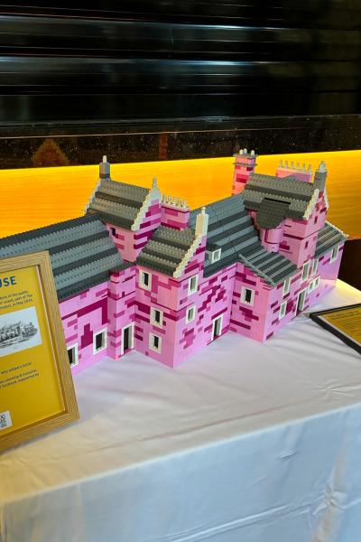 A pink lego house on a white table