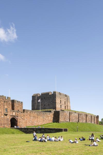 The castle keep from a distance, surrounded by greenery. 