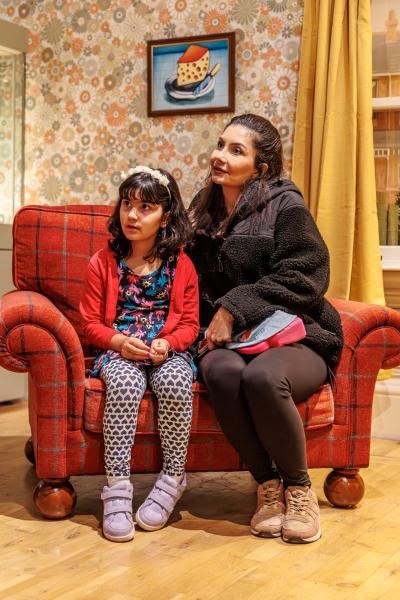 a lady sits on an armchair with her daughter