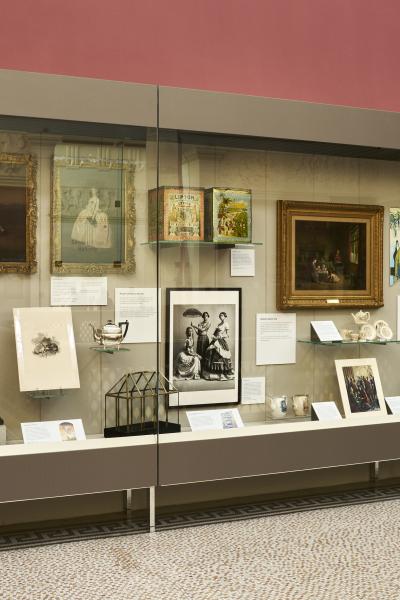 Lots of exhibits and items of interest inside a glass cabinet inside a museum.
