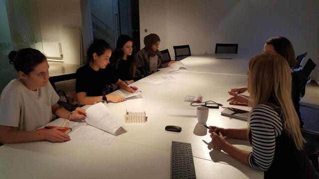 female staff members sat around table in meeting room