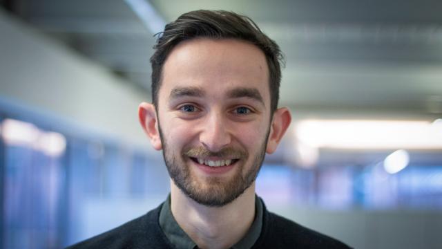 headshot of adam lewis, smiling