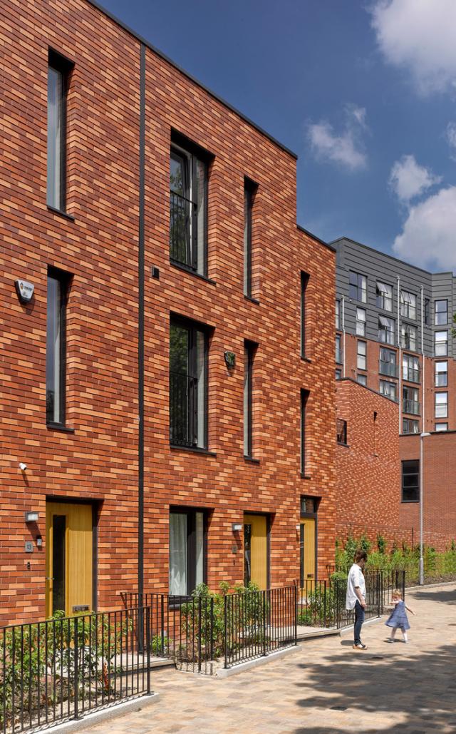 Row of terraced houses with a woman and girl in front. 