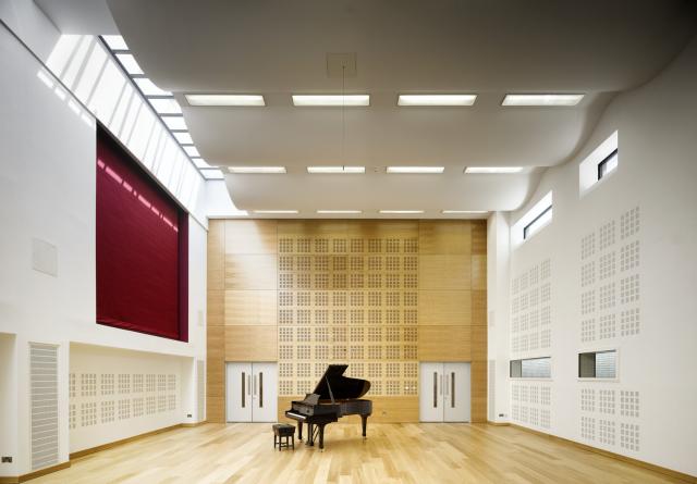 Image of a large orchestral rehearsal space with a piano.