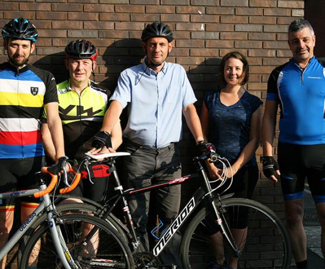 group of staff cyclists posing outside of studio