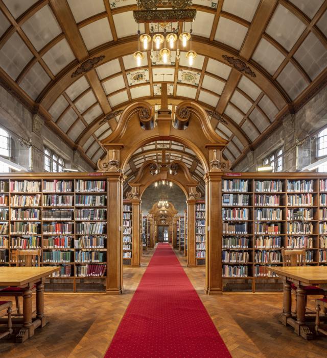 a library with curved roof and red carpet running centrally