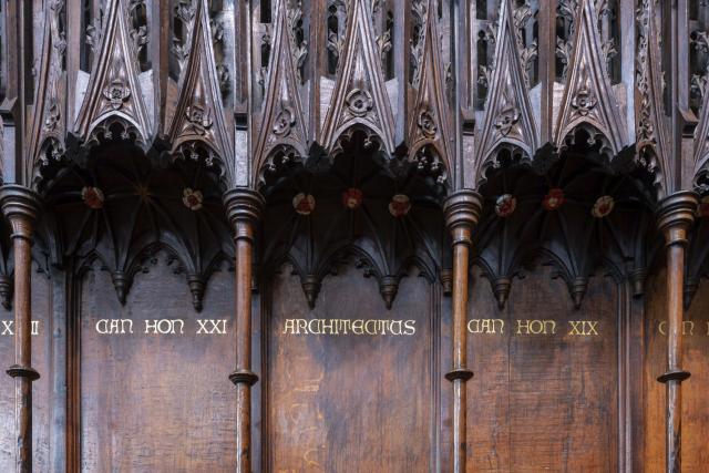 a carved dark wood screen in lincoln cathedral