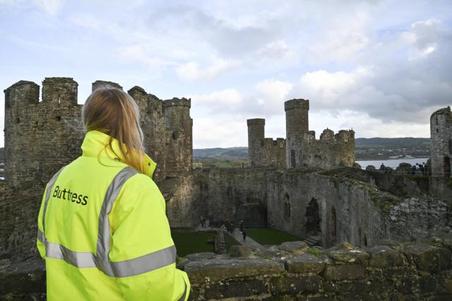 A woman looking at World Heritage Site, Caernarfon Castle.