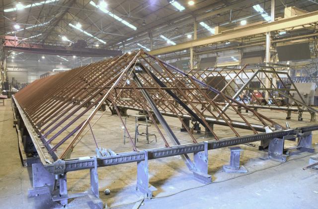 The steel frame of a Victorian glasshouse being pieced back together off-site.