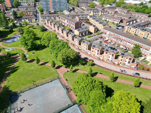 An aerial photo with a curved row of houses facing a park
