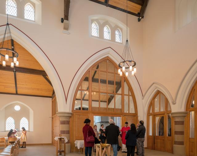 Interior of Church of the Ascension. A group of the congregation gathered outside the kitchen.