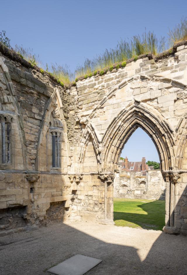 the walls of a stone ruin with an arch looking through to the rest of the site