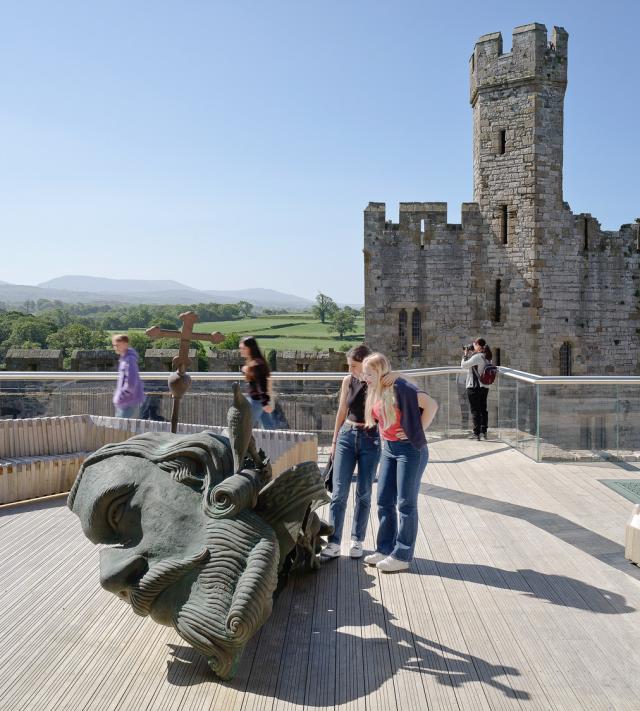 two girls look at the sculpture on the deck at caernarfon castle